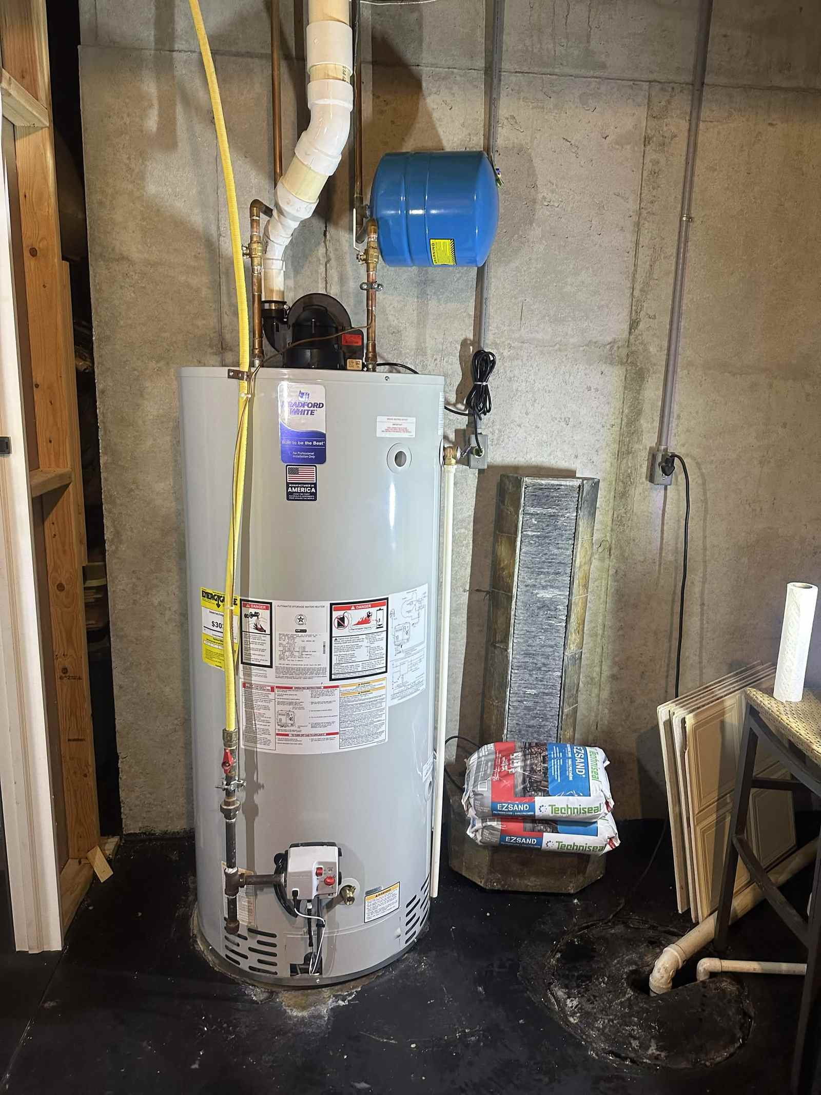 Gas water heater with an expansion tank installed in a basement.